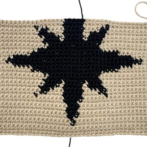 Modern crochet wall hanging pattern featuring a bold black eight-pointed star on a neutral background. This is a digital PDF pattern for instant download, not a finished product.