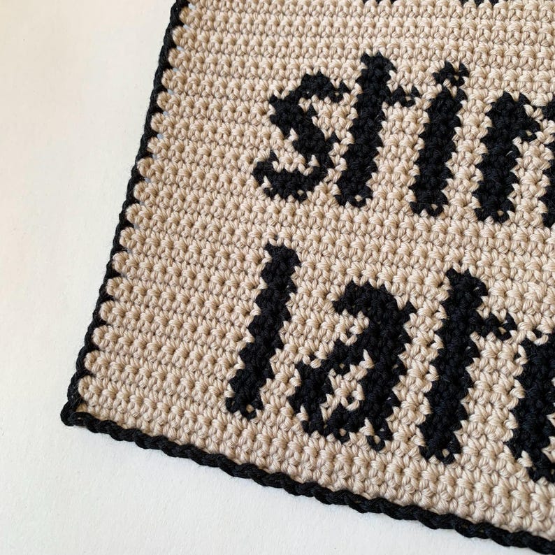 Digital crochet pattern for a wall tapestry featuring the word "Overstimulated" in bold black gothic-style lettering on a beige background. The pattern includes instructions to create the tapestry, which is bordered with black crochet edging. This listing is for the pattern only, not a finished item.