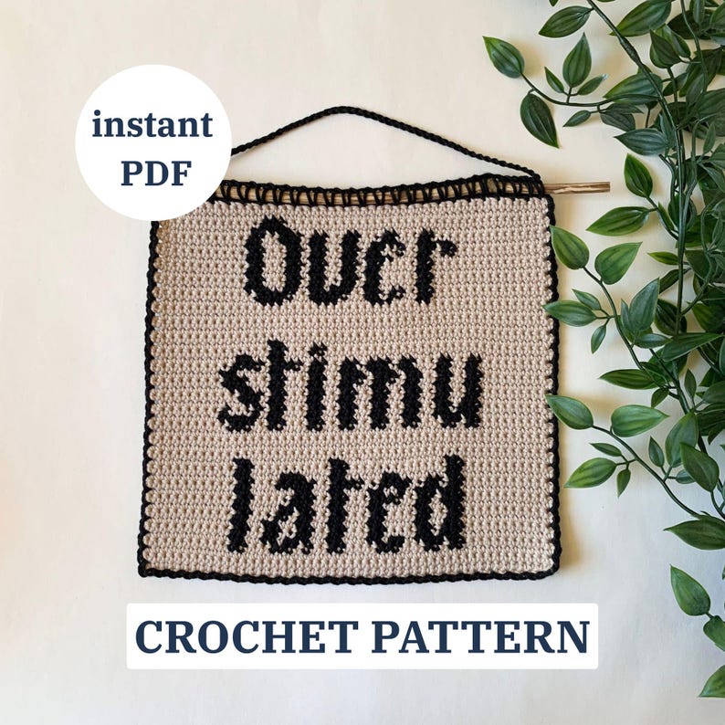Digital crochet pattern for a wall tapestry featuring the word "Overstimulated" in bold black gothic-style lettering on a beige background. The pattern includes instructions to create the tapestry, which is bordered with black crochet edging. This listing is for the pattern only, not a finished item.