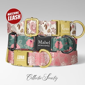 May include: Three dog collars with floral patterns and personalized nameplates. The top collar has a beige background with pink flowers, the middle one has a teal background with pink flowers, and the bottom one has a pink background with white accents. The collars have gold and black hardware.