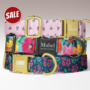 May include: Three dog collars with floral patterns in pink, teal, and a watercolor floral design. The collars have gold-colored metal hardware and are personalized with names and phone numbers. A red circle with the word "SALE" is in the top left corner.