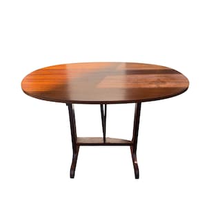 Op de afbeelding: Een ronde houten tafel met een donkerbruine afwerking. De tafel heeft een glad, gepolijst oppervlak en een donkerbruin, gebogen potenontwerp. De tafel heeft een diameter van ongeveer 102 cm.
