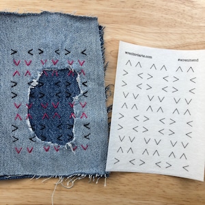 May include: A denim patch with a hole in the centre, surrounded by black and pink stitching in a chevron pattern. The patch is next to a sheet of paper with the text "wrenbirdarts.com" and "#wrenmend" printed on it. The paper is covered in black chevron patterns.