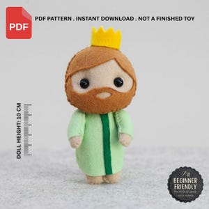 Op de afbeelding: Een PDF-patroon voor een viltpopje van een koning met een gele kroon, bruin haar en baard, en een lichtgroen gewaad. De pop heeft zwarte kraaloogjes en een hoogte van 10 cm. De tekst luidt: PDF PATTERN. INSTANT DOWNLOAD. NOT A FINISHED TOY.