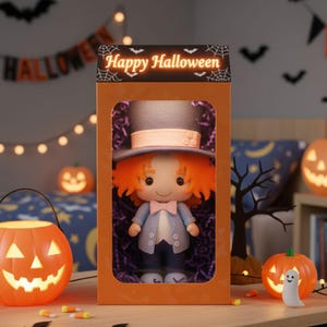 May include: A Halloween-themed doll in an orange box, featuring a top hat, orange hair, and a blue suit. The box is labeled "Happy Halloween" with spiderweb accents. Lit jack-o'-lanterns and candy corn are in the foreground, creating a festive scene.