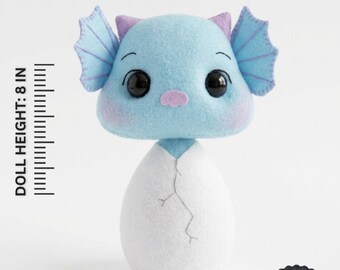May include: A PDF pattern for a felt doll featuring a light blue creature with large black eyes, purple ears, and a white egg-shaped base with a crack design. The doll height is 20.32 cm. Text includes PDF PATTERN, INSTANT DOWNLOAD, NOT A FINISHED TOY, and BEGINNER FRIENDLY.