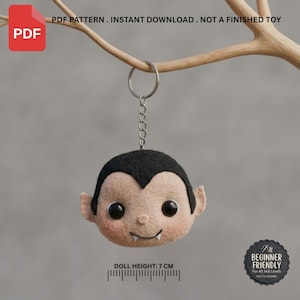 May include: A felt vampire head keychain with black hair, pale skin, round black eyes, and two white fangs. The text reads PDF PATTERN . INSTANT DOWNLOAD . NOT A FINISHED TOY and DOLL HEIGHT: 7 CM. A badge states BEGINNER FRIENDLY For All Skill Levels.