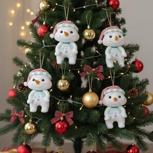 May include: A Christmas tree adorned with snowman decorations, red and gold baubles, and tartan bows. The snowman ornaments are white with pink and blue details, each with a carrot nose and a blue scarf.