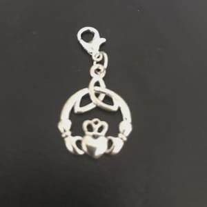 May include: Silver-toned Claddagh charm with a lobster clasp. The charm features a heart, crown, and hands design, encircled by a Celtic knot. The Claddagh symbol represents love, loyalty, and friendship. This charm is suitable for jewelry making or as a pendant.