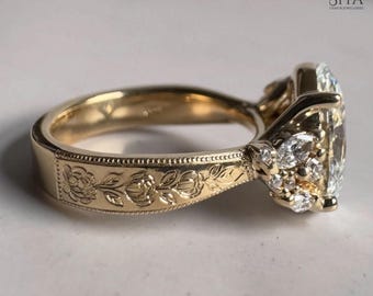 May include: A gold ring with a large, clear, rectangular-cut gemstone and smaller accent stones. The band features a floral pattern and the ring is set against a neutral background. The SIYA logo is visible in the upper right corner.