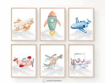 May include: Six framed watercolor prints featuring various aircraft: a biplane, rocket, jet, propeller plane, helicopter, and another biplane. Each image has a white background with a watercolor cloud effect. The color palette includes shades of orange, blue, red, and gray.