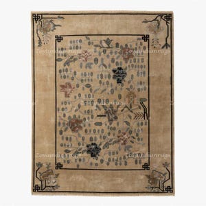 Peut inclure: Un tapis rectangulaire beige avec un motif floral et une bordure noire. Le tapis présente un motif central de fleurs et de feuilles dans des tons marron, bleu et gris. Les coins ont des motifs floraux décoratifs. Le texte "Zoyaindianrugs" est visible.