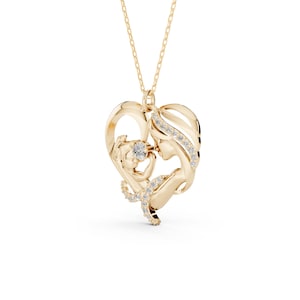 Op de afbeelding: Een goudkleurige hangerketting met een ontwerp van een moeder en kind in een hartvorm. De hanger is versierd met kleine, sprankelende edelstenen. De ketting hangt aan een fijne gouden ketting.