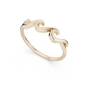 May include: A gold-colored ring with a wave design. The ring features three connected wave shapes, creating a continuous, flowing pattern. The ring is set against a white background.
