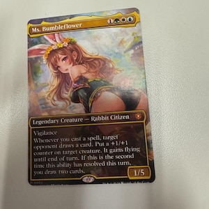May include: A Magic: The Gathering trading card titled Ms. Bumbleflower, featuring a legendary rabbit citizen creature with long ears, a flower crown, and brown hair. The card displays game text, mana symbols, and a power/toughness rating of 1/5.