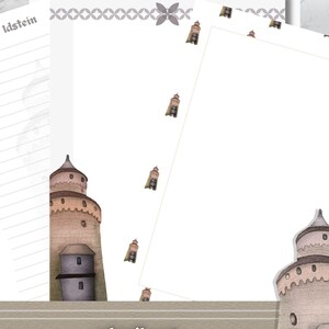May include: Stationery set with a watercolour illustration of a medieval tower. The set includes lined and blank paper with a decorative border and small tower accents. The text "Hexenturm Idstein" and "schreib set" are visible.