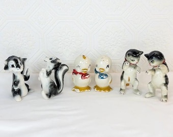 Saleros y pimenteros vintage con diseños de animales: mofetas, patos y gatos.