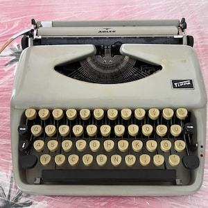Máquina de escribir Adler Tippa vintage, color crema y negro, teclado QWERTZ, con estuche, años 60, Alemania