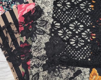 Bundel zwarte stof, kant, kleedjes, benodigdheden voor tijdschriften