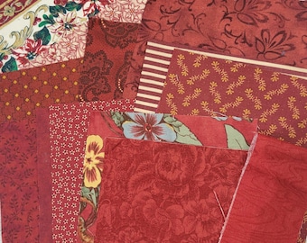 Bundel bordeauxrode stof, kant, kleedjes, benodigdheden voor tijdschriften