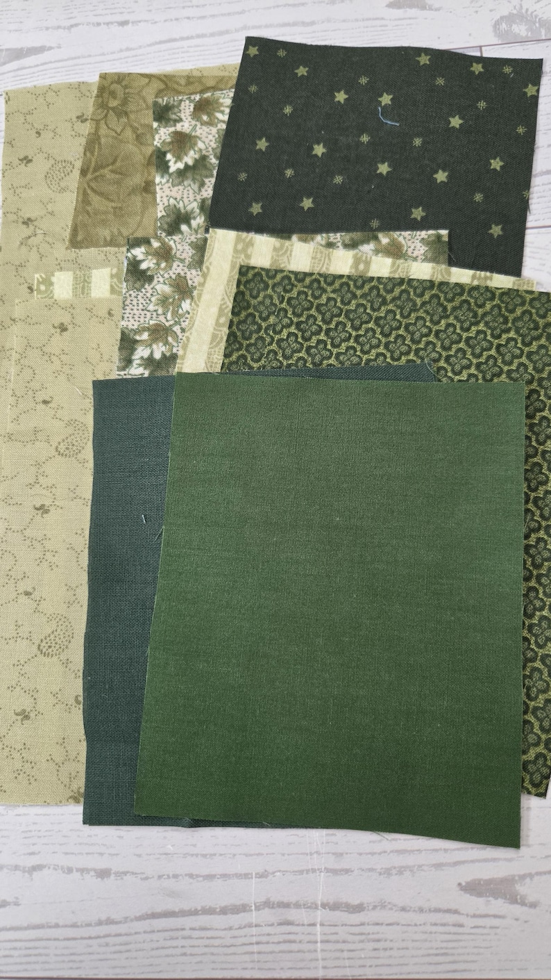 Puede incluir: Una colecci&oacute;n de retazos de tela rectangulares en varios tonos de verde y beige. Los patrones incluyen verde oscuro s&oacute;lido, un fondo verde oscuro con peque&ntilde;as estrellas, un estampado de tr&eacute;bol verde, un estampado floral beige y un patr&oacute;n de hojas beige.
