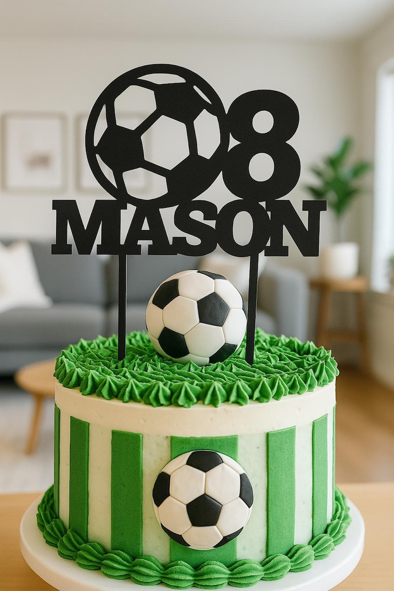 May include: A soccer-themed birthday cake with green and white stripes and a soccer ball decoration. The cake is topped with a black cake topper that reads "08 MASON" and a soccer ball.