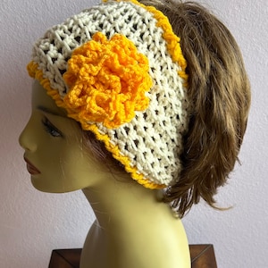May include: White crochet headband with a yellow crocheted flower accent. The headband is designed to be worn with a ponytail.