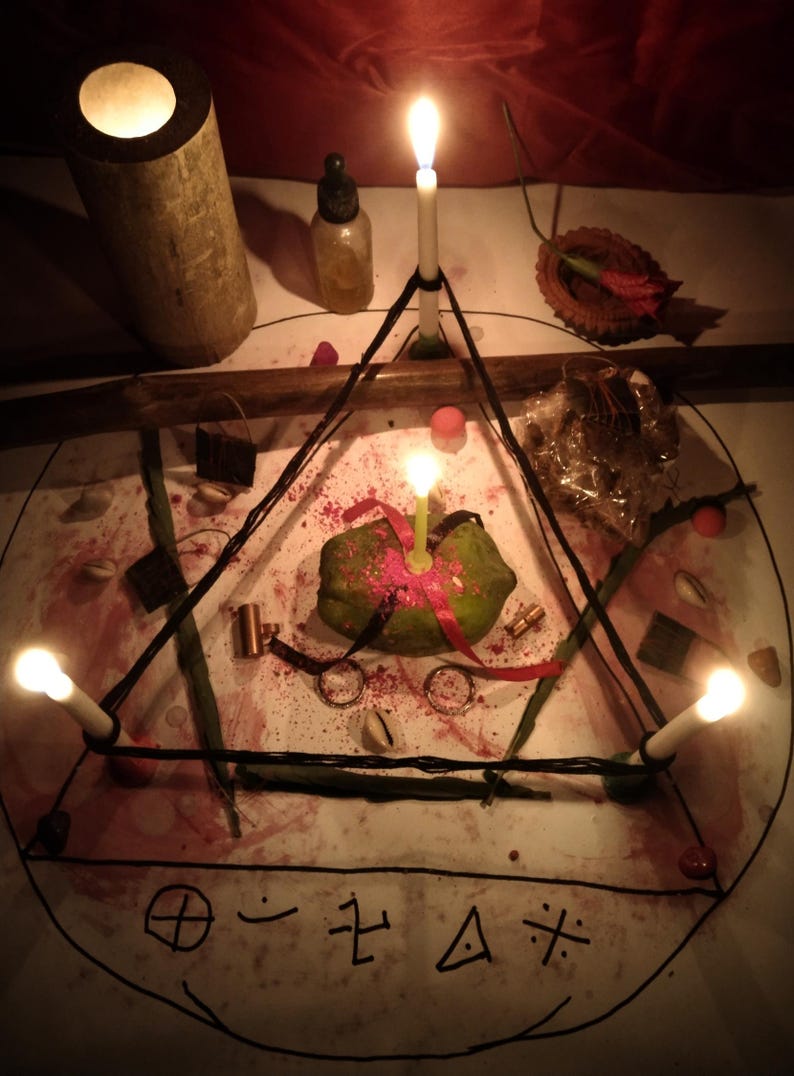 Puede incluir: Una superficie circular blanca con un tri&aacute;ngulo negro y s&iacute;mbolos dibujados a mano, iluminada por cuatro velas blancas finas. Un objeto verde en el centro con cintas rojas, rodeado de peque&ntilde;os anillos met&aacute;licos, un frasco y ramitas.