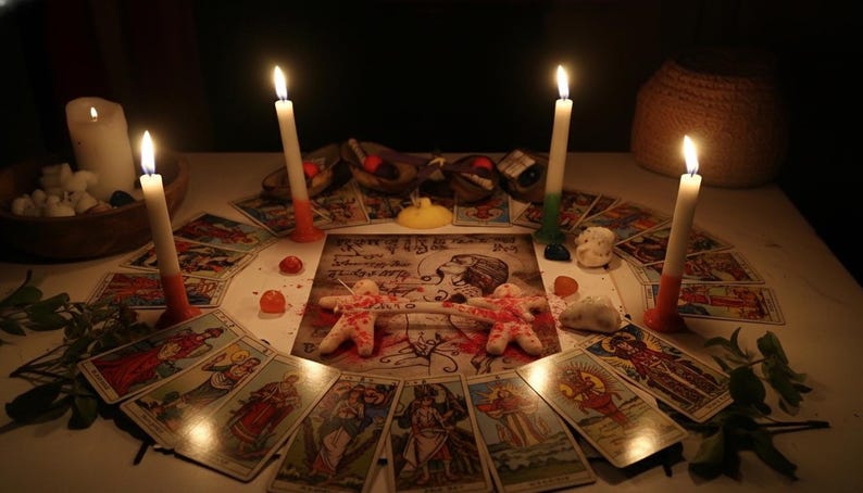 K&ouml;nnte beinhalten: Eine kreisf&ouml;rmige Anordnung von Tarotkarten um einen zentralen rechteckigen Druck, der eine Zeichnung einer Person und zwei kleine Stoffpuppen zeigt, die durch ein wei&szlig;es Band verbunden sind. Vier brennende Stabkerzen stehen um die Karten herum.