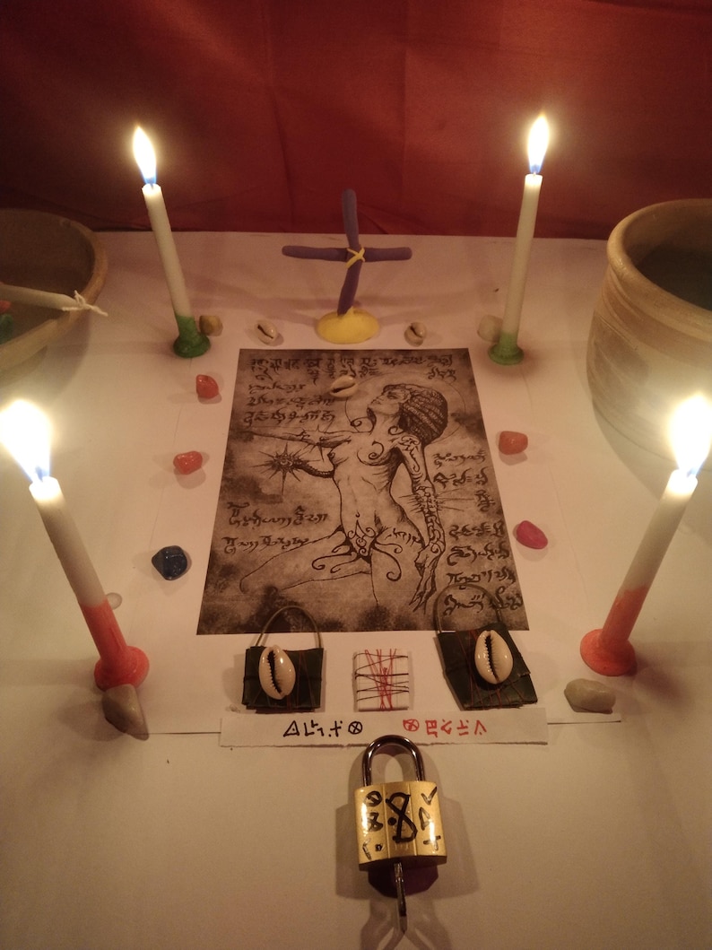 K&ouml;nnte beinhalten: Ein rituelles Arrangement mit vier brennenden Kerzen, einem zentralen Druck einer Figur mit komplexen Linien und Schriftzeichen, zwei kleinen dunklen Beuteln mit Kaurimuscheln, einem kleinen gewickelten B&uuml;ndel und einem Messingvorh&auml;ngeschloss.