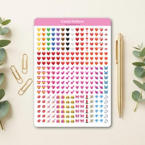 Könnte beinhalten: Ein Bogen mit Emoji-Aufklebern mit verschiedenen Designs, darunter Herzen, Schmetterlinge und Geschenke. Die Aufkleber sind in verschiedenen Farben gehalten und tragen den Text "Emoji Stickers". Ein goldener Stift und Büroklammern sind ebenfalls im Bild.