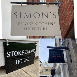 Può includere: Tre insegne di negozi. L'insegna superiore recita "SIMON'S BESPOKE KITCHENS FURNITURE". La seconda insegna è nera con testo bianco che recita "STOKE BANK HOUSE". La terza insegna recita "Nanna's YARN BARN".
