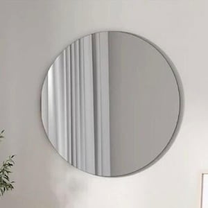 Könnte beinhalten: Ein großer, runder Wandspiegel mit einem dünnen, neutralfarbenen Rahmen. Die reflektierende Oberfläche zeigt eine klare Sicht auf vertikale weiße Vorhänge, was für ein helles und sauberes Erscheinungsbild sorgt. Der Spiegel hängt an einer hellen Wand.