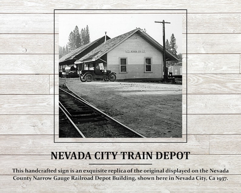 May include: Black and white photograph of a train depot building in Nevada City, California. The building has a sign that reads "Nevada City". A car is parked in front of the building.