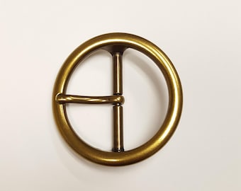 Hebilla circular básica con acabado chapado en latón.