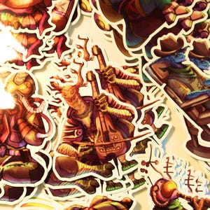May include: A selection of vibrant stickers depicting fantasy characters. The stickers show a variety of creatures, including a deer-like figure with a double-necked instrument, and a blue-skinned cowboy.