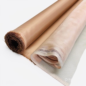 May include: Two rolls of fabric are displayed. One is a solid, smooth, tan material, and the other is a beige mesh fabric. The rolls are partially unrolled, revealing the texture and color variations. The fabrics are on a white background.