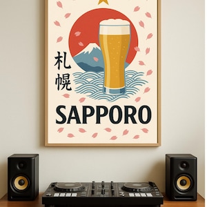 May include: A framed poster with a Japanese-inspired design featuring a beer glass, a red sun, and the word "SAPPORO". The poster is surrounded by pink cherry blossom petals. Two black speakers and a DJ mixer sit on a wooden surface.