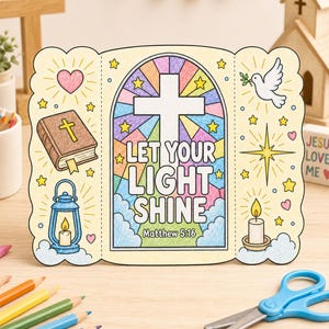 May include: A tri-fold paper craft featuring a central stained glass window design with a white cross and the text "LET YOUR LIGHT SHINE Matthew 5:16". The side panels display a brown Bible, a blue lantern, a white dove, and a yellow star.