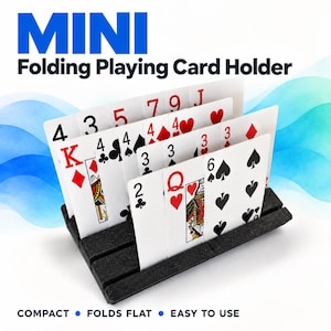 May include: A black, textured, mini folding playing card holder with three horizontal slots holding multiple standard playing cards. The text "MINI Folding Playing Card Holder" appears at the top, and "COMPACT • FOLDS FLAT • EASY TO USE" is at the bottom.