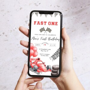 May include: A smartphone displays a red and white race car themed birthday invitation. The invitation reads "Fast One" and includes a race car illustration, balloons, and the text "Alex's First Birthday".
