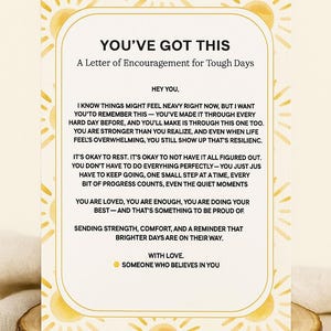 以下が含まれることがあります： 「YOU'VE GOT THIS」の文字が金色のフレームに収められた、木のスライスの上に置かれたモチベーションカード。困難な日のための励ましのメッセージが書かれており、黄色の太陽のデザインが施されています。