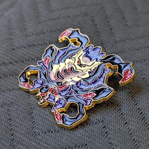May include: A detailed enamel pin featuring a stylized scorpion design. The pin has a gold outline and is filled with shades of blue, purple, red, and gold. The scorpion's body is intricately detailed, making it a unique accessory.