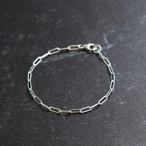 May include: A silver chain bracelet with a simple, linked design.