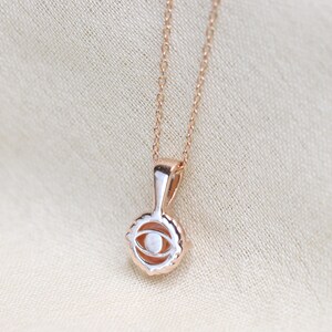 May include: A rose gold necklace with a delicate eye pendant. The pendant is detailed with a white stone in the center.
