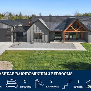 May include: Exterior view of a modern barndominium with a gray metal roof and siding. The home features a covered porch with wooden beams, a two-car garage, and a well-manicured lawn. The image includes text that reads "BP-2001 BRASHEAR BARNDOMINIUM 3 BEDROOMS".