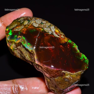 May include: A white ceramic mug with a black handle and the text "But First, Coffee" in a bold, black font. The mug is set against a blurred background, suggesting a cozy setting.