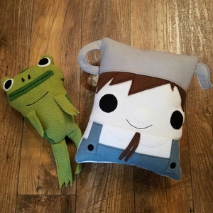 Par-dessus le mur du jardin, Greg, une grenouille, un oreiller, une peluche, un coussin,