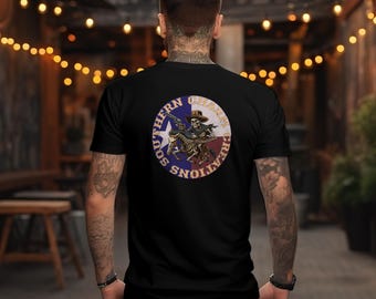 Peut inclure: T-shirt noir avec un motif circulaire au dos. Le motif représente un cowboy squelette chevauchant un cheval squelette, tenant une arme à feu, avec les mots "Southern Charm Creations" sur le bord. Le design intègre les couleurs du drapeau du Texas.
