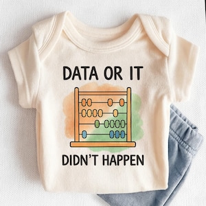 May include: Cream-colored baby onesie with the text "DATA OR IT DIDN'T HAPPEN" above a colorful abacus graphic. The onesie is paired with a pair of blue denim pants. A fun and educational outfit for a baby.